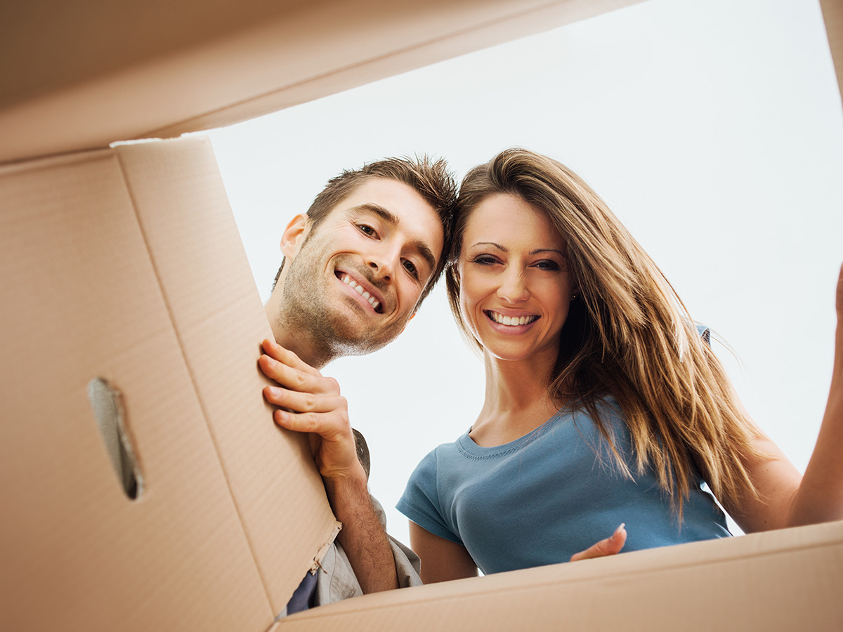 A couple smiling while looking into a box